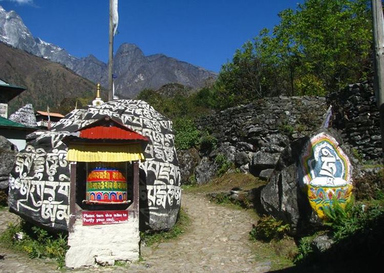 Mani Wall ( Buddhist shrine ) with Prayer Flags and Prayer Wheels